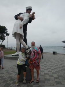 Cathy and Ken in front of statue of sailor and woman hugging.