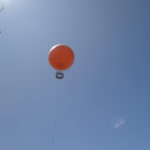 large orange hot air balloon in blue sky