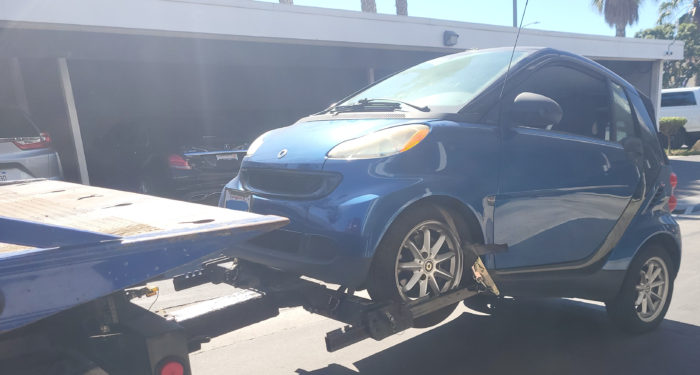 Blue Smart Car being towed away