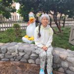 Cathy sitting next to funny penguin sculpture