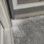 Corner of patio where hail has accumulated in a small pile
