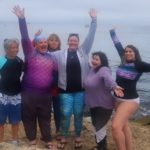 Group of women posing celebrating on beach